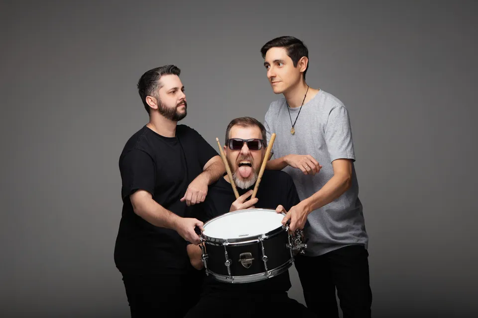 Momento descontraído de um ensaio fotográfico da banda com uma caixa de bateria